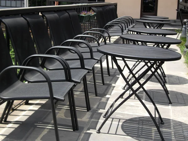Черные стулья и столы - вид на город — стоковое фото