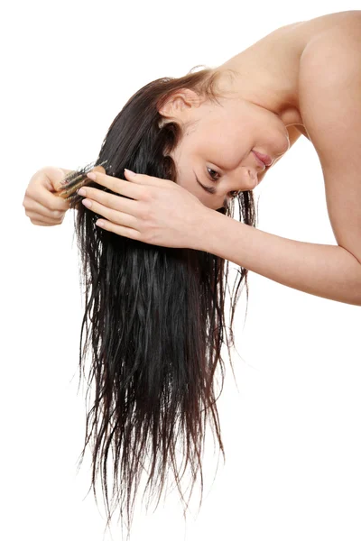 Bella giovane donna spazzolatura capelli — Foto Stock