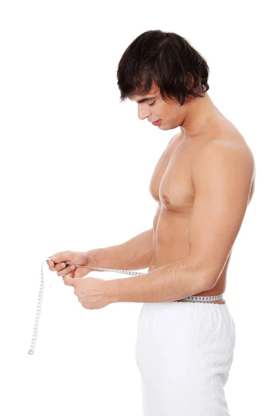 Young man's measuring himself. — Stock Photo, Image