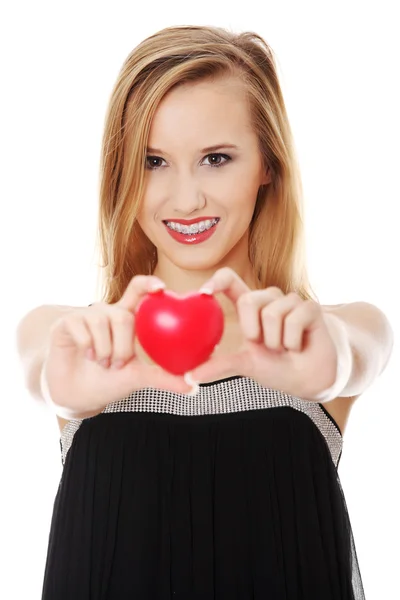 Krásná mladá žena příležitostné drží červené srdce — Stock fotografie