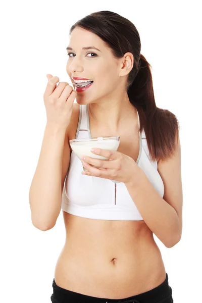 Jovem mulher comendo iogurte — Fotografia de Stock