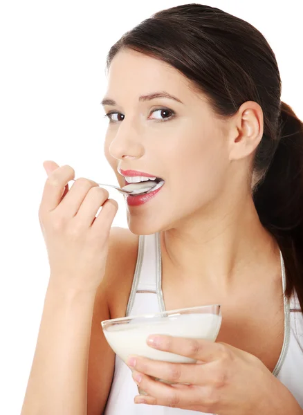 Молодая красивая женщина ест йогурт — стоковое фото