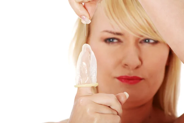 Зріла жінка робить дірку в презервативі — стокове фото