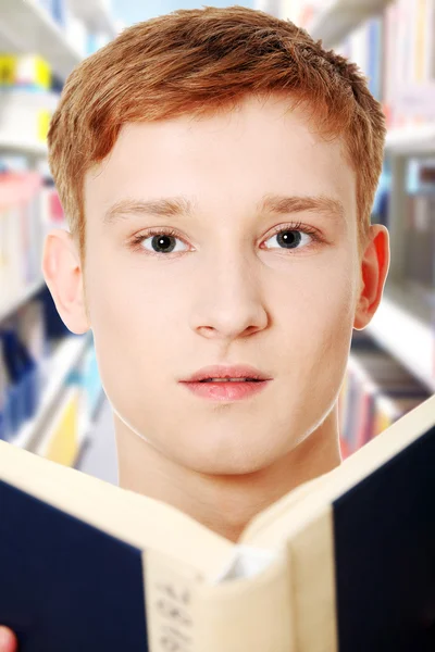Joven adolescente hombre está leyendo un libro — Foto de Stock