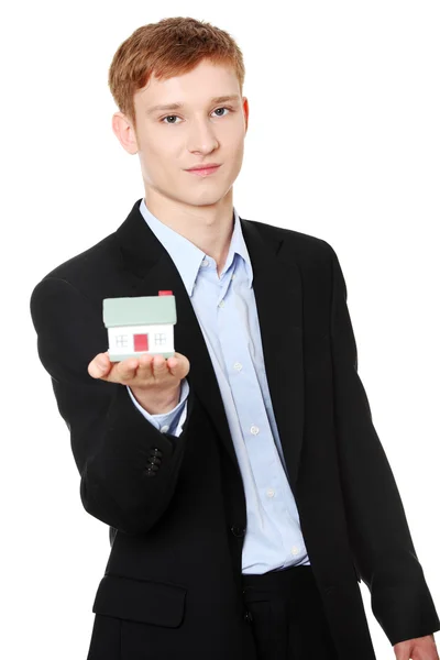 Молодой бизнесмен держит модель дома — стоковое фото