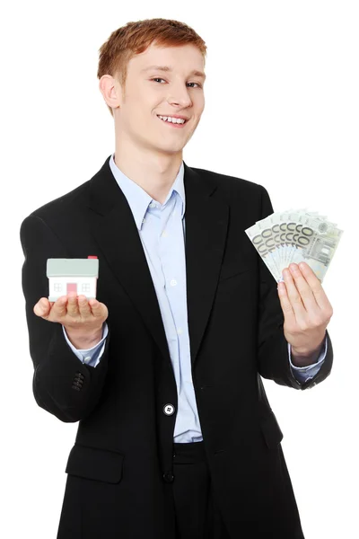 Businessman with money and house's model. — Stock Photo, Image