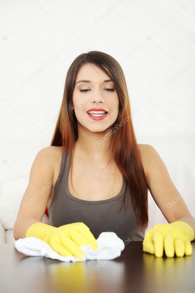 Young woman cleaning furniture table