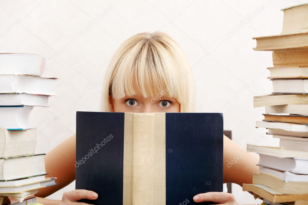 Student woman with lots of books studying for exams.