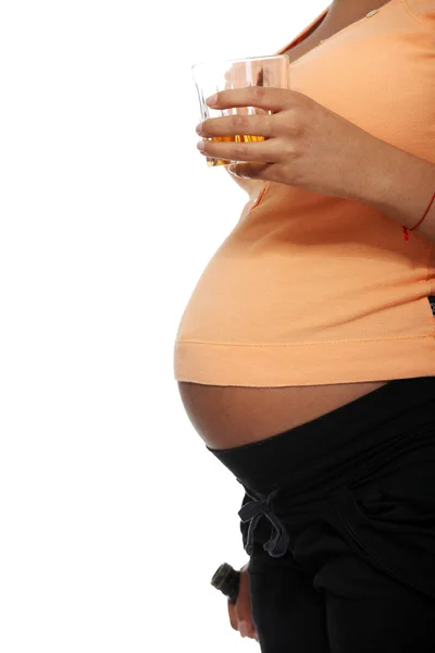Беременная женщина держит стакан, полный алкоголя — стоковое фото