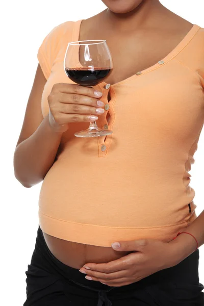 Беременная женщина держит стакан, полный алкоголя — стоковое фото