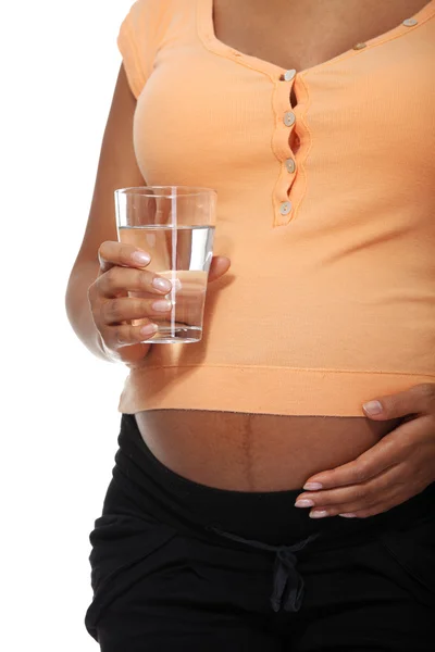 Pregnant belly with glass of water — Stock Photo, Image