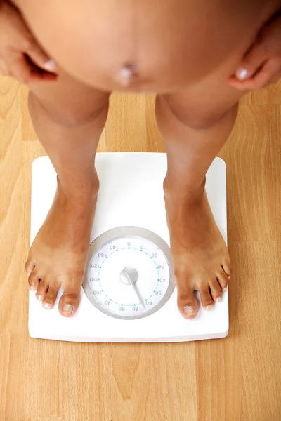 Mujer embarazada comprobando su peso — Foto de Stock
