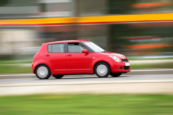 Blur pequeña familia económica roja coche compacto ciudad —  Fotos de Stock