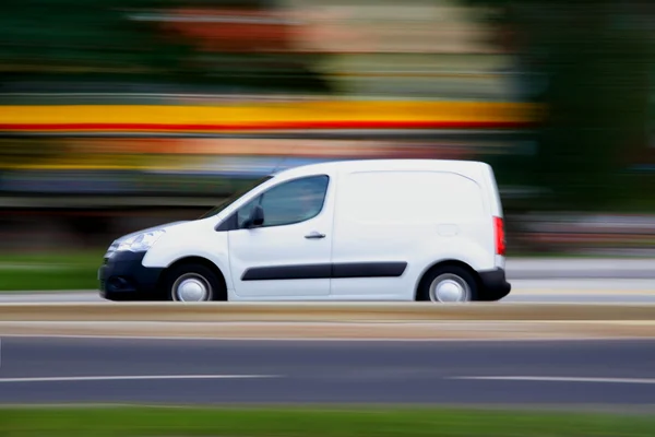 Speedy minivan branca está indo na estrada — Fotografia de Stock