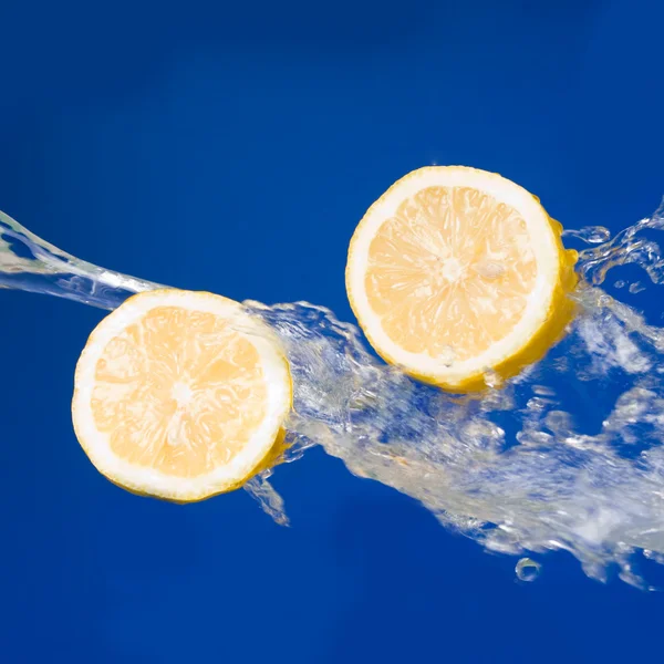 stock image Two halves of lemon in the splashes of water