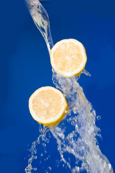 stock image Two halves of lemon in the splashes of water