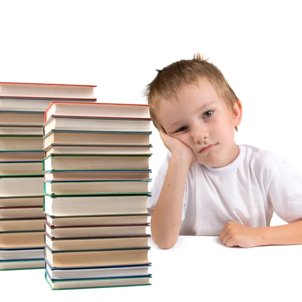 Tired schoolboy sits at the table — Stock Photo, Image