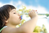 Kind trinkt reines Wasser in der Natur