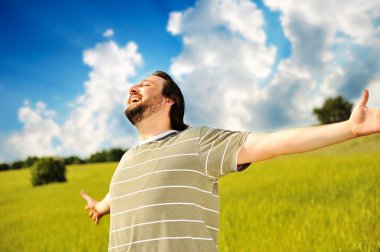 Happy succesful man in nature with wide open arms clipart