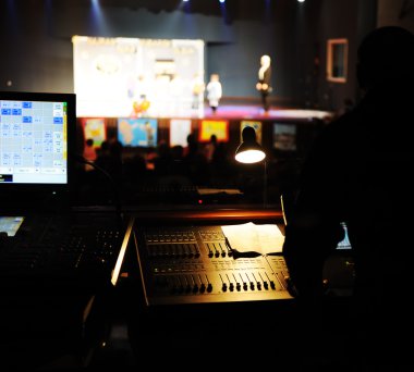 Sound engineer at mixing desk, children performance out of focus clipart