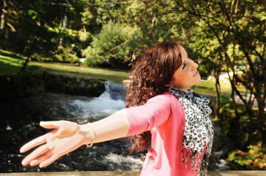 Young happy relaxed girl in nature breathing fresh air clipart