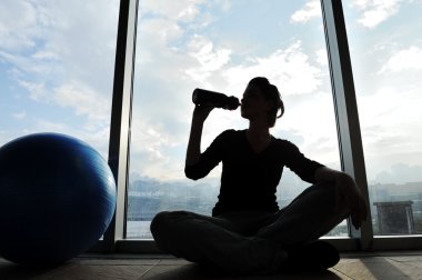 Fitness sporty girl silhouette excercising and drinking a water clipart