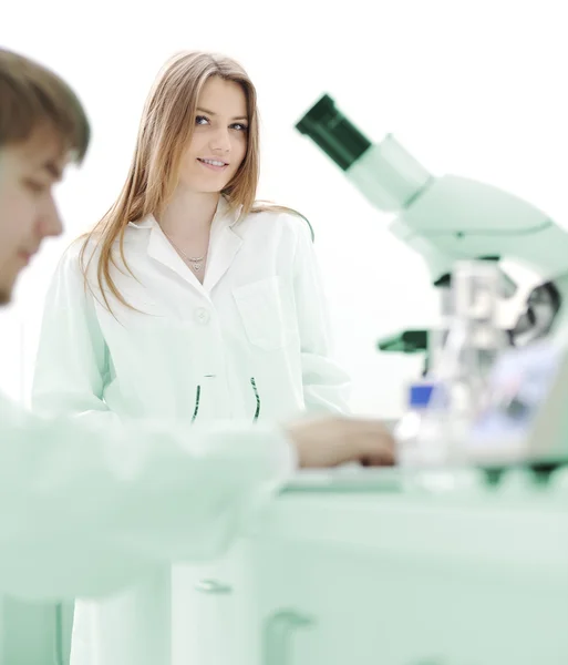 Two female scientists working at the laboratory with microscope — Stock Photo, Image