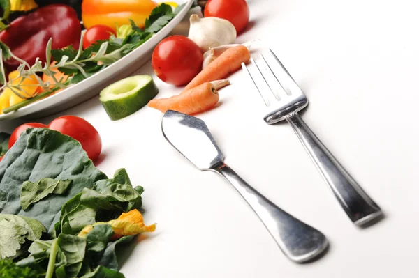Forchetta e coltello in tavola, ingredienti alimentari, molte verdure intorno — Foto Stock