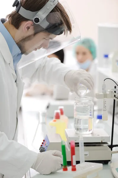 Group of the students working at the laboratory with liquids in tubes and e — Stock Photo, Image