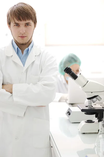 Dois cientistas que trabalham no laboratório com microscópio — Fotografia de Stock