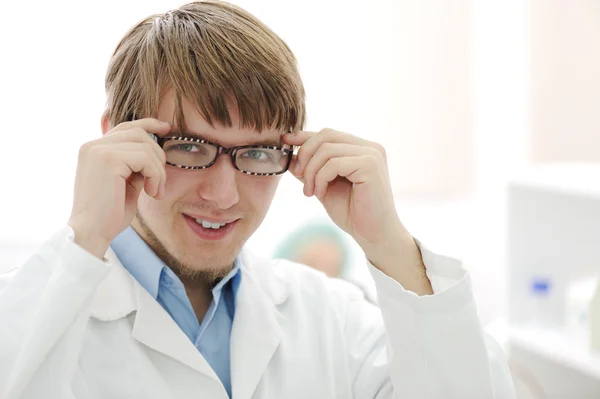 Retrato de jovem pesquisador no laboratório, trabalhador hospitalar com óculos — Fotografia de Stock
