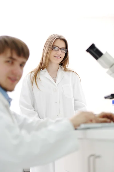 科学チームが研究室で顕微鏡の操作 — ストック写真