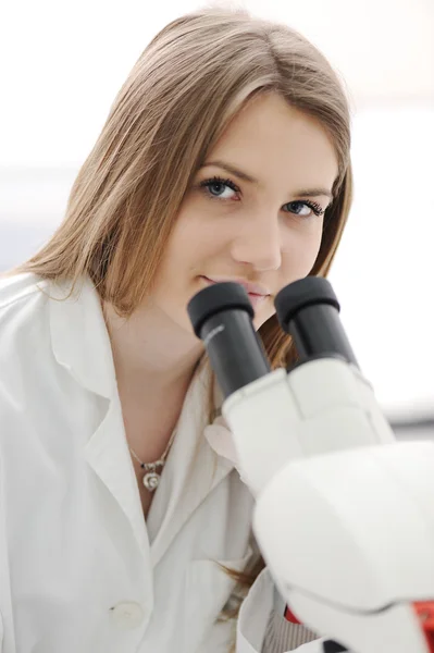 在实验室中，特写镜头使用显微镜的美丽女研究员 — 图库照片