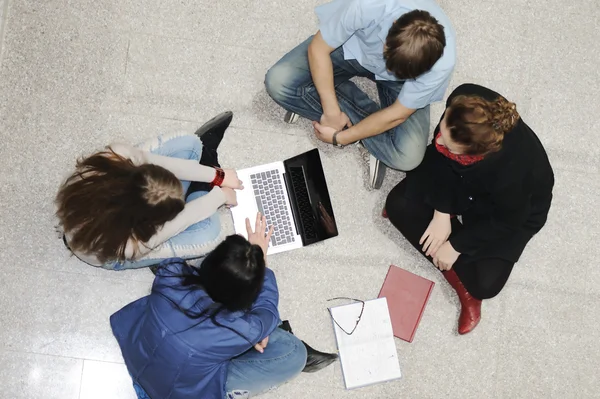 Grupo creativo de estudiantes sentados y trabajando juntos — Foto de Stock