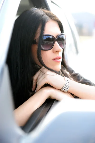 Mooie aantrekkelijke vrouw in auto, kijkend naar het venster — Stockfoto