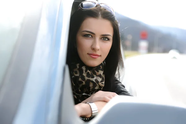 Beautiful attractive woman in car, looking through the window — Stock Photo, Image