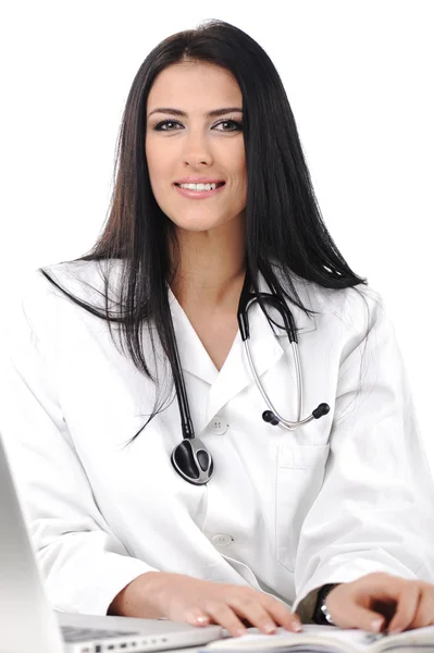 Unga läkare kvinna ser till kamera med leende, sitter på hennes skrivbord — Stockfoto
