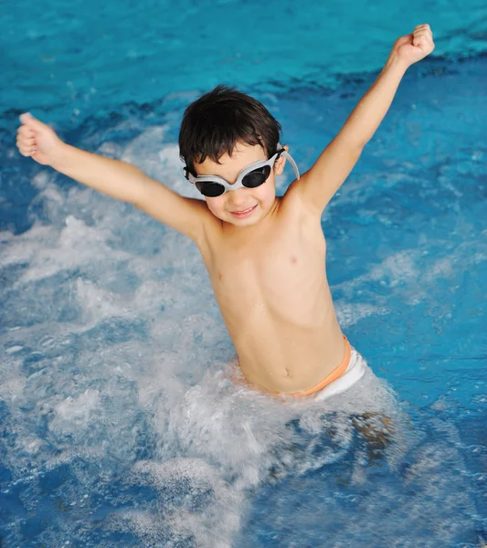 Malý roztomilý chlapec v modré vodě bazénu, letní čas pro zábavu — Stock fotografie