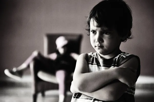 Old style photography: angry boy standing in front of relaxed girl in chair — Stock Photo, Image