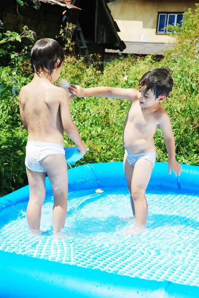 Niños en el agua azul de la piscina, hora de verano para divertirse al aire libre — Foto de Stock