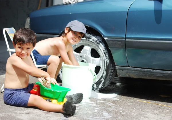 Игры вокруг автомобиля и уборка, дети в летнее время — стоковое фото