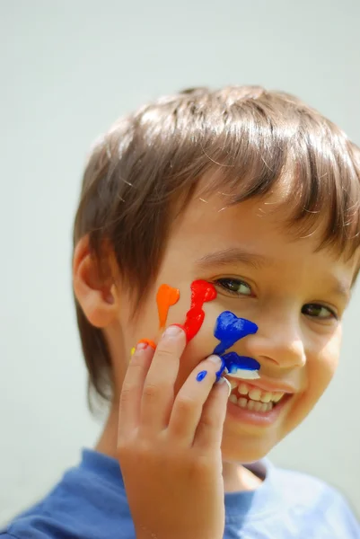 孩子与他的手指和脸上的颜色 — 图库照片