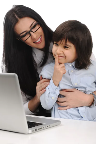 Glückliche junge schöne Mutter und süßer kleiner Sohn auf dem Laptop am Tisch — Stockfoto