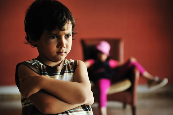 Régi stílusú fotózás: dühös fiú nyugodt lány a szék előtt áll — Stock Fotó