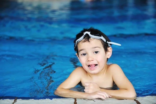 水泳プールの青い水の中に小さなかわいい男の子、楽しいための夏時間 — ストック写真