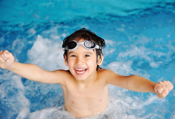 Kleine schattige jongen in blauw water van het zwembad, zomertijd voor de lol — Stockfoto