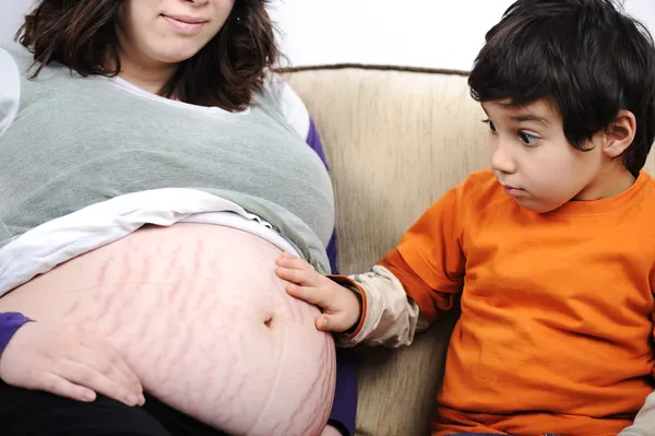 Een kleine jongen en zijn zwangere moeder doorbrengen tijd samen — Stockfoto