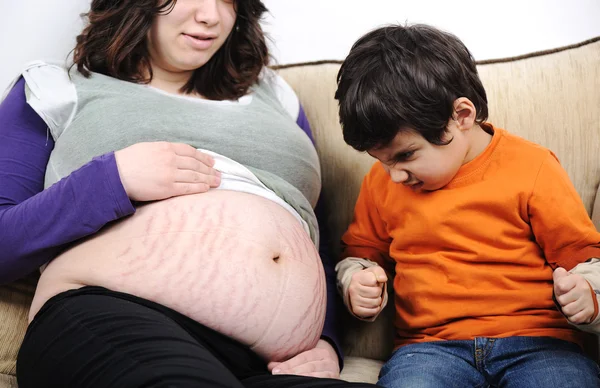 Angry son on his new brother or sister - pregnant mother, funny scene — Stock Photo, Image