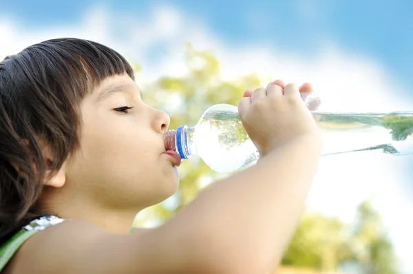 Niño bebiendo agua pura en la naturaleza — Foto de Stock