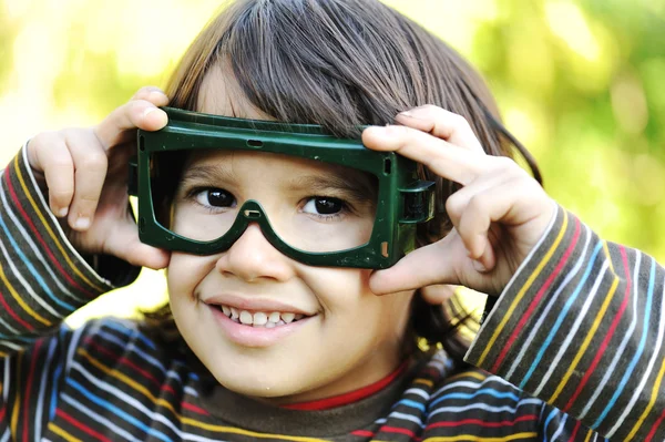Um pequeno piloto, garoto bonito ao ar livre com óculos nos olhos — Fotografia de Stock